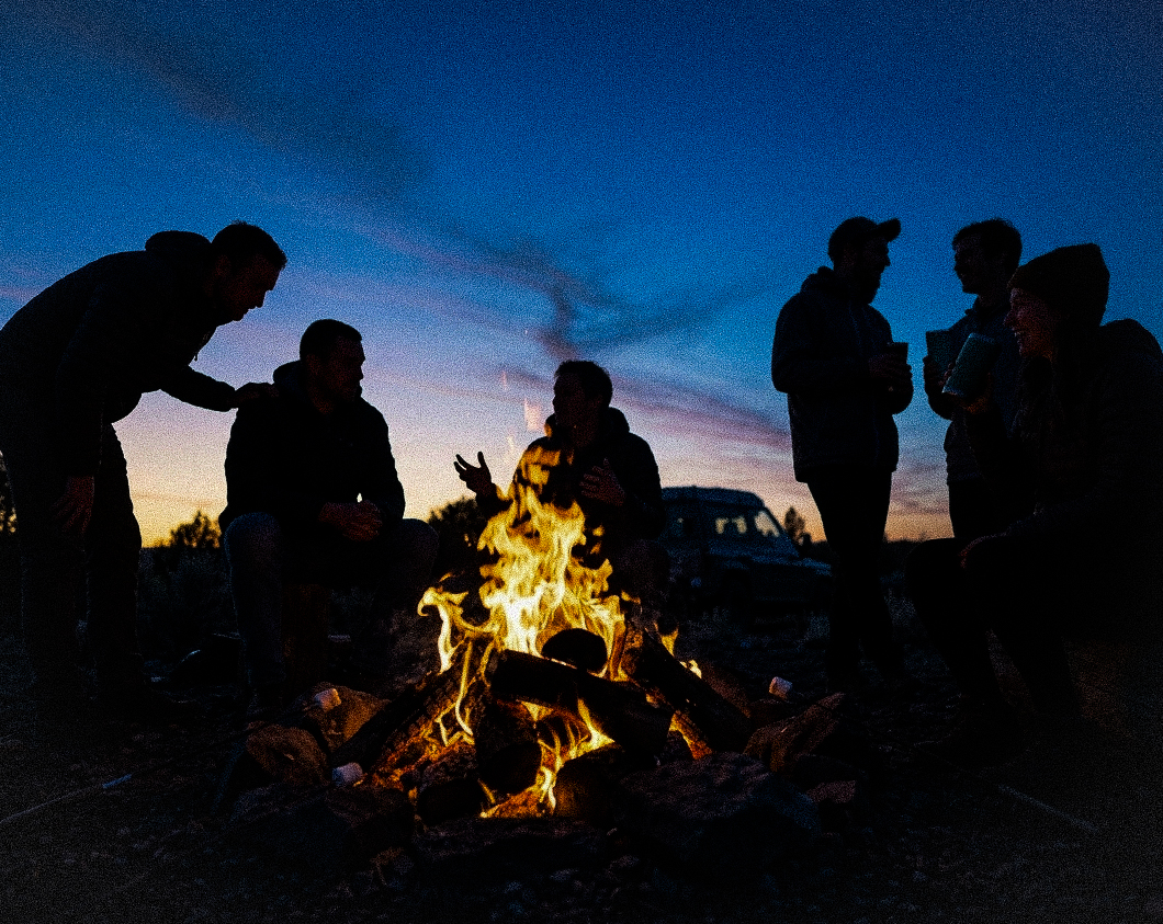 A small group around a campfire in private conversation